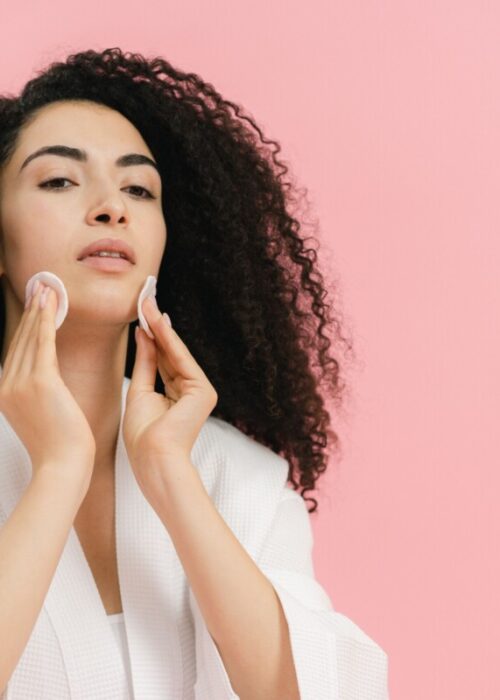 Donna durante la detersione del viso, passaggio centrale della skincare anti smog per chi vive in città